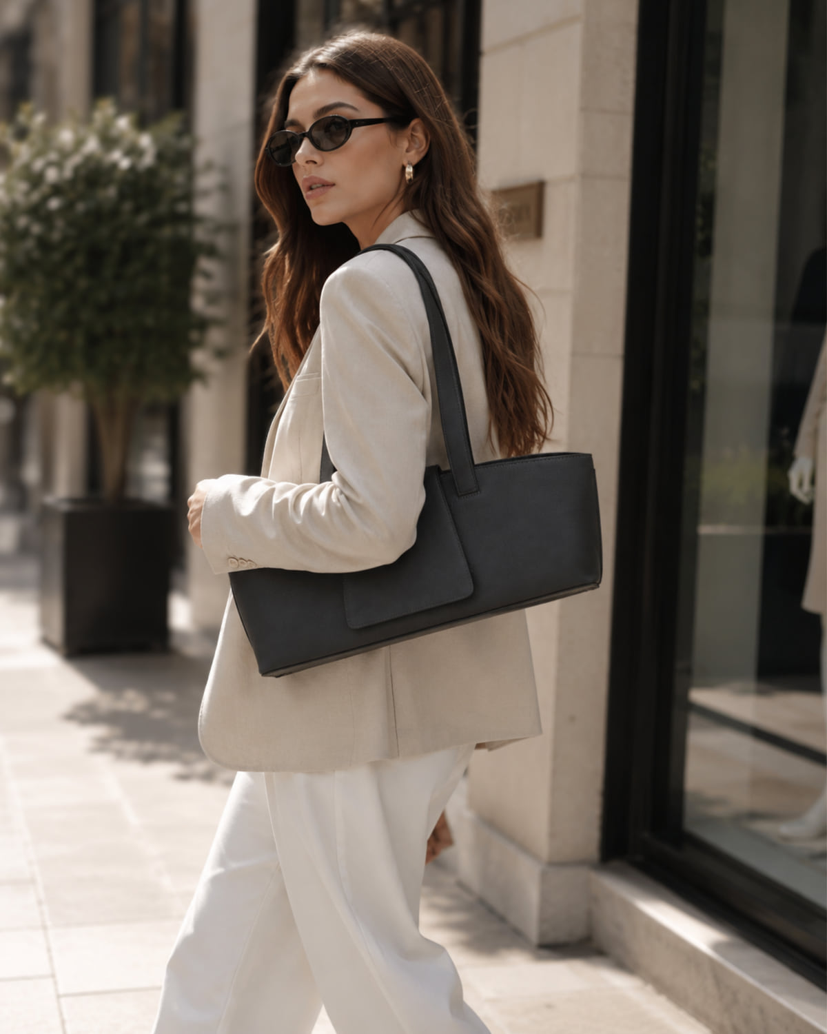 The Sloane in slate leather, held under the arm with its structured front flap facing forward